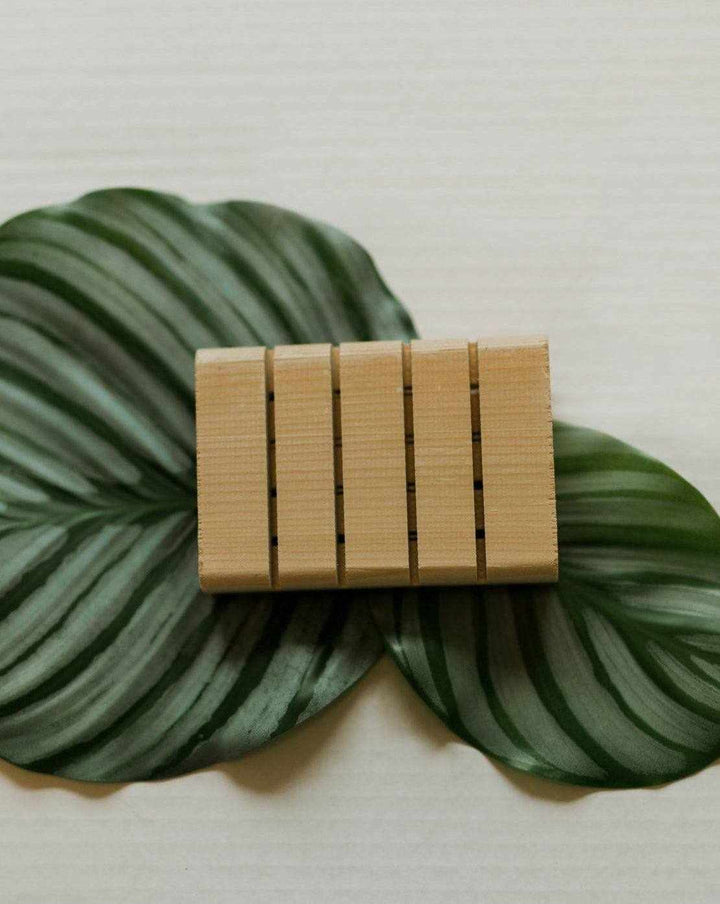 Handcrafted cedar soap tray with grooves for water drainage, showcasing natural wood grain and aroma