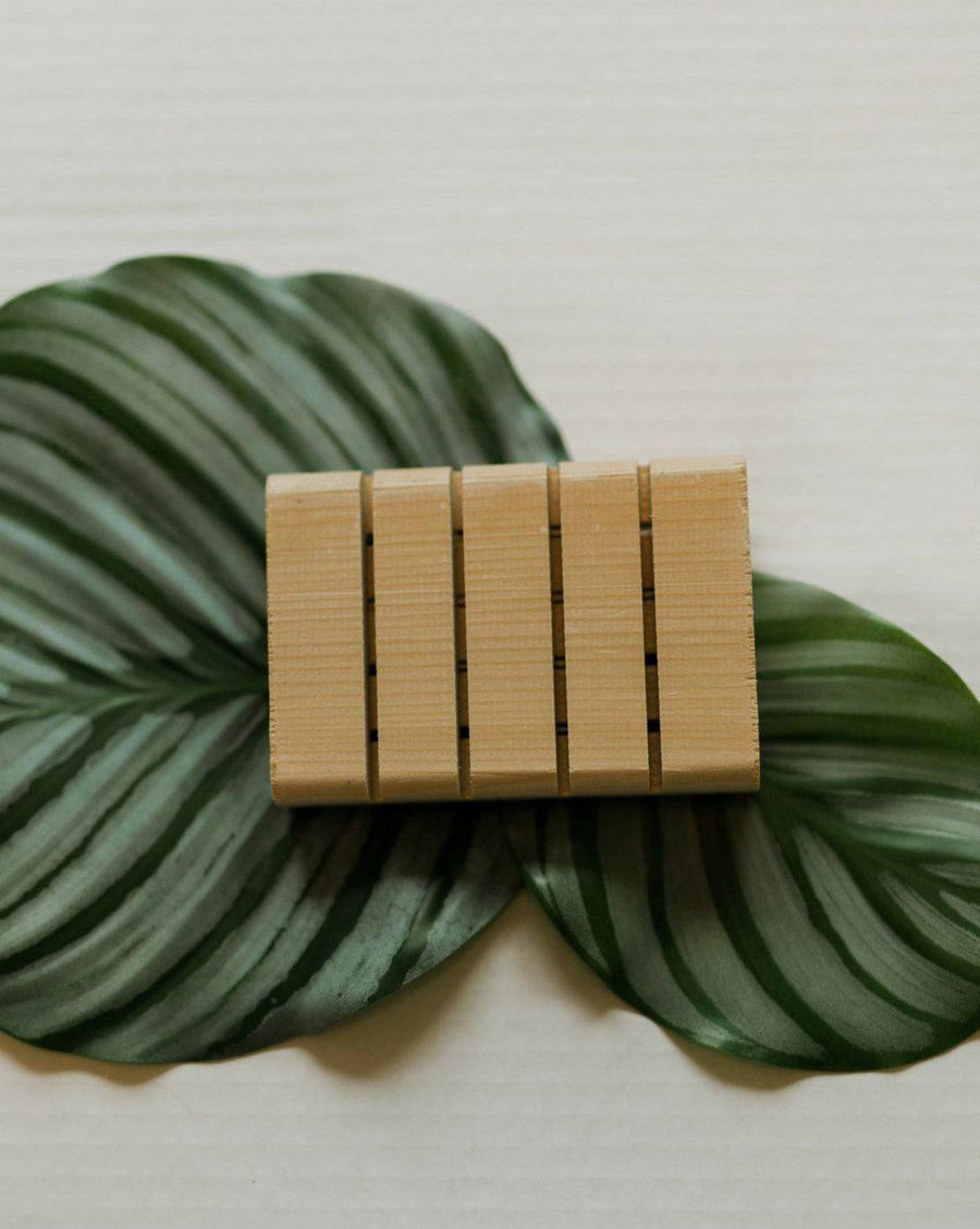 Handcrafted cedar soap tray with grooves for water drainage, showcasing natural wood grain and aroma