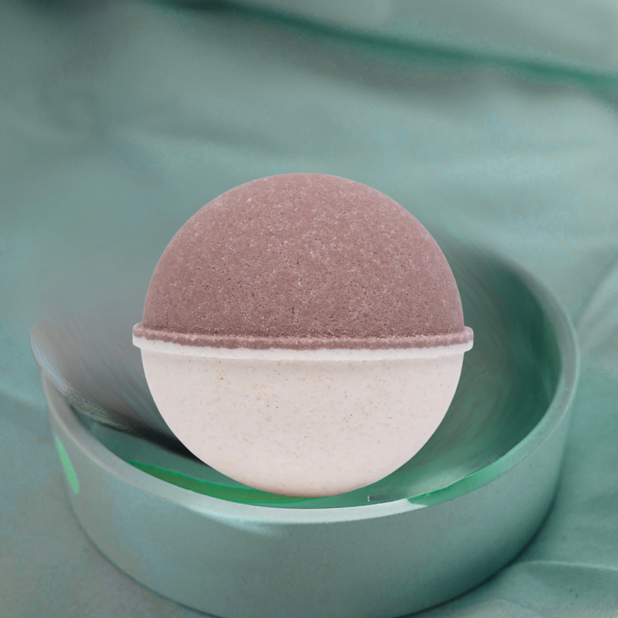 Oatmeal Milk & Honey bath bomb fizzing in water with natural sprinkles and nourishing ingredients